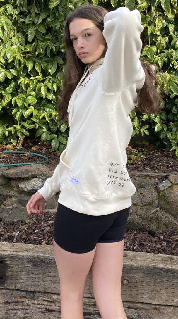 Model wearing White Embroidered Fleece Hoodie showing the design on the front and back and ribbed style on side