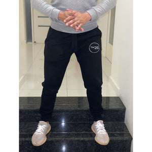 Open image in slideshow, Customer flashing luxury lavish lifestyle and posing on stairs wearing Supreme Black Sweatpants With Embroidered Logo and showing off the new yeezy&#39;s
